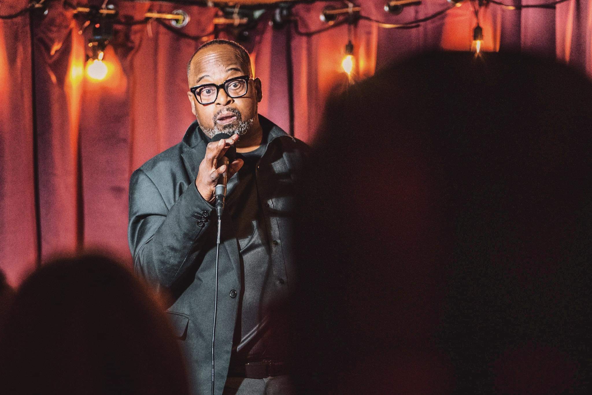 Sean Williams performing stand-up on stage
